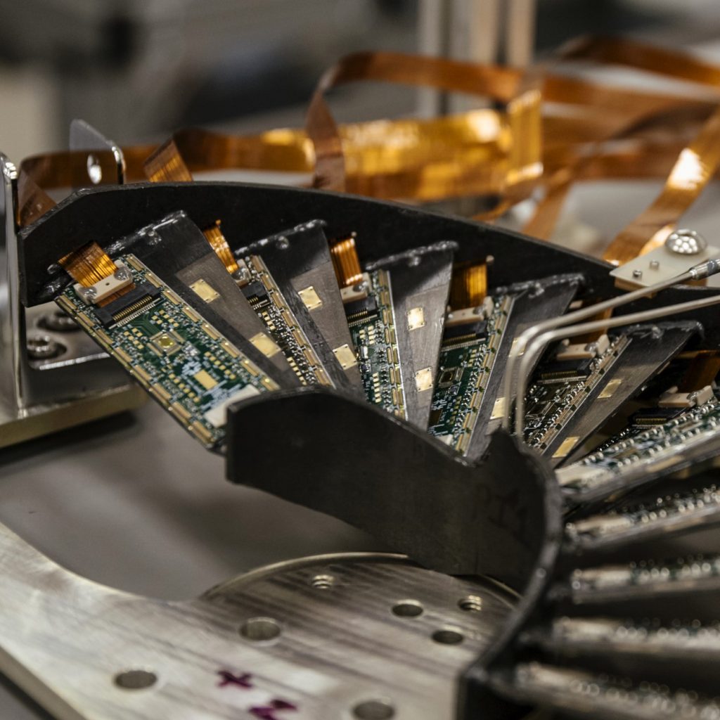 Fan of silicon pixel detector modules with gold flex cables mounted on a curved metal frame