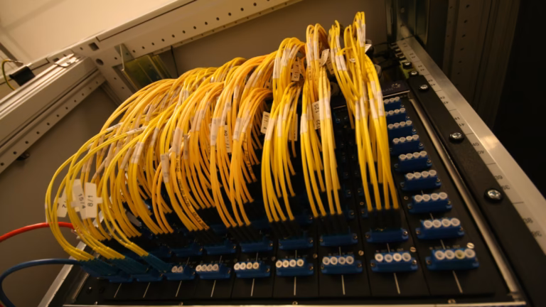 Bundles of yellow fibre patch cables plugged into an optical patch panel at the AMS-IX Internet exchange in Amsterdam