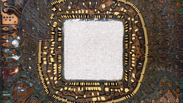 Inside a ball grid array chip package: copper routing traces in the organic substrate fan out from the central die area