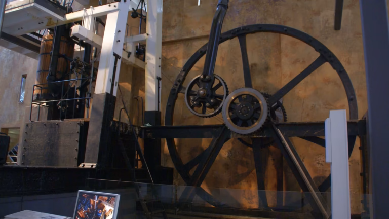 The Boulton and Watt beam engine of 1785 on display in a museum, showing its large iron flywheel and sun-and-planet gearing