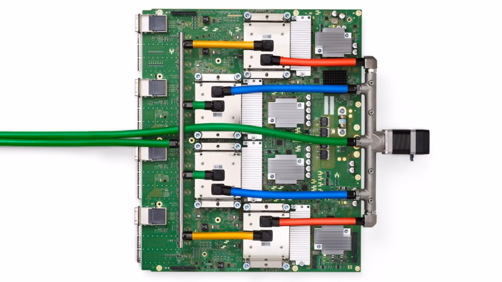 A Google TPU v4 board carrying four liquid-cooled TPU packages, with coolant hoses and cables attached