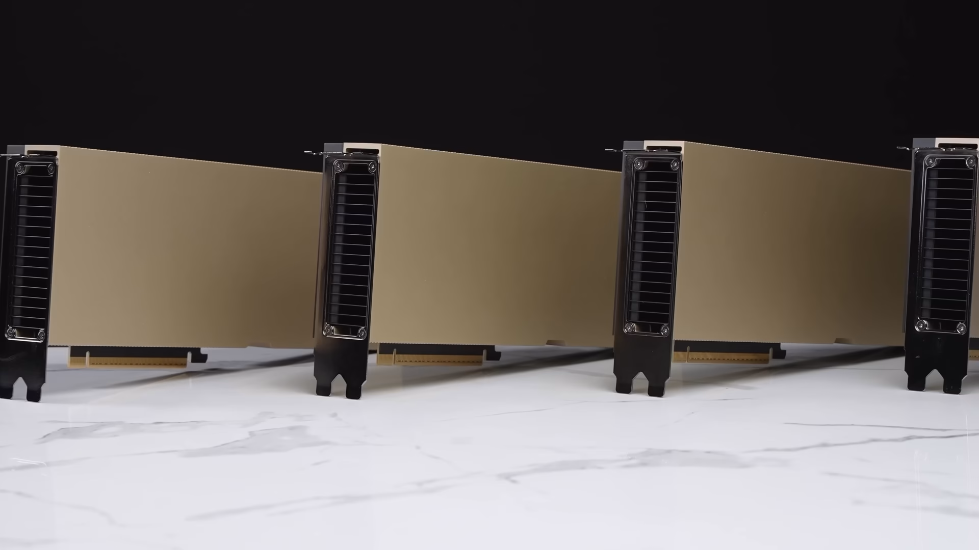 Four NVIDIA H100 PCIe accelerator cards standing in a row on a white marble surface against a black background.
