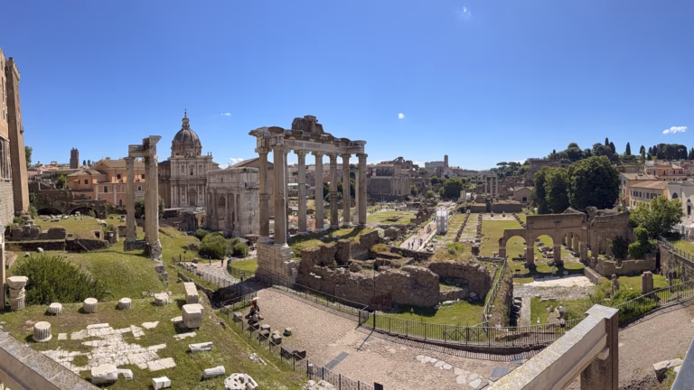 Panorama of the Roman Forum ruins in Rome, with the columns of the Temple of Saturn, the Arch of Septimius Severus and the Colosseum in the distance