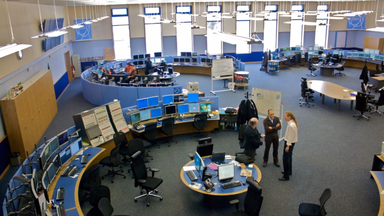 Ingegneri e operatori al lavoro nel CERN Control Centre, tra file di console e monitor che gestiscono gli acceleratori del laboratorio