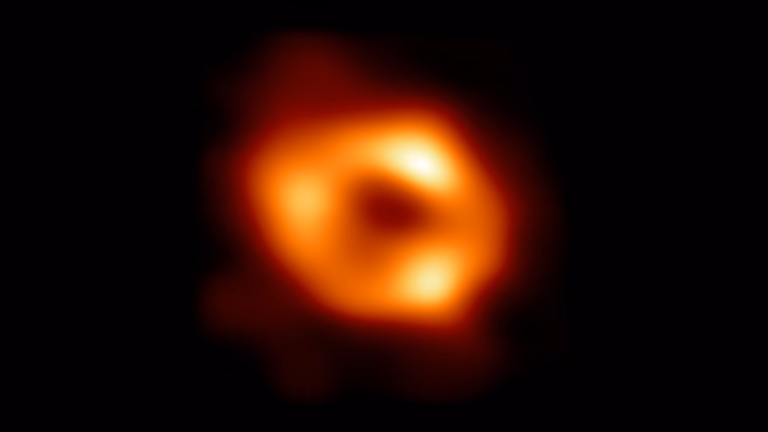 Immagine dell'Event Horizon Telescope di Sagittarius A*, il buco nero supermassiccio al centro della Via Lattea: un anello arancione di gas caldo attorno a un'ombra centrale scura