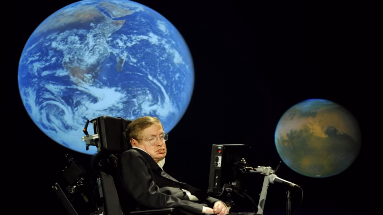 Stephen Hawking in his wheelchair on stage at George Washington University in 2008, with projected images of Earth and Mars behind him, during his lecture for NASA's 50th anniversary
