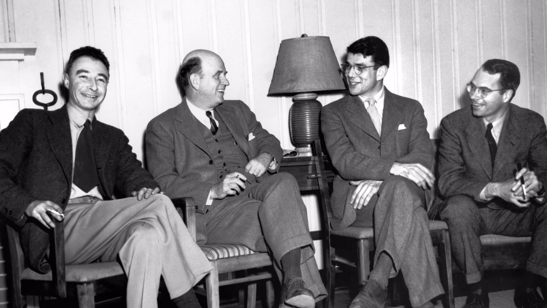 J. Robert Oppenheimer, seated on the left, laughing with members of the State Department's atomic energy consultants in the lobby of the Oak Ridge guest house, Tennessee, in February 1946