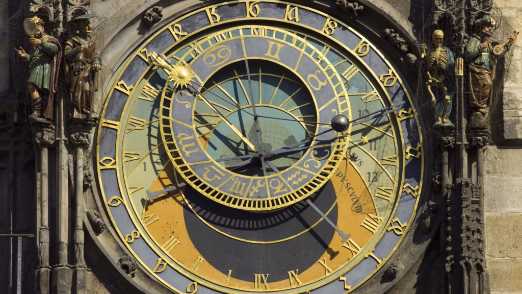 Il quadrante dell'orologio astronomico di Praga, con anelli dorati delle ore e dello zodiaco e le statue animate ai lati, tra cui uno scheletro che rappresenta la Morte