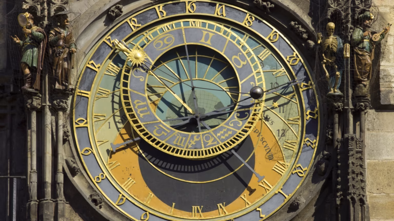 Il quadrante dell'orologio astronomico di Praga, con anelli dorati delle ore e dello zodiaco e le statue animate ai lati, tra cui uno scheletro che rappresenta la Morte