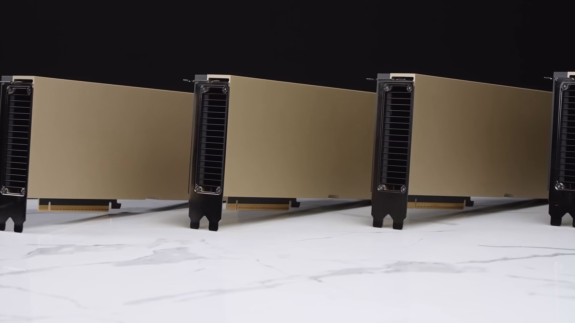 Four NVIDIA H100 PCIe accelerator cards standing in a row on a white marble surface