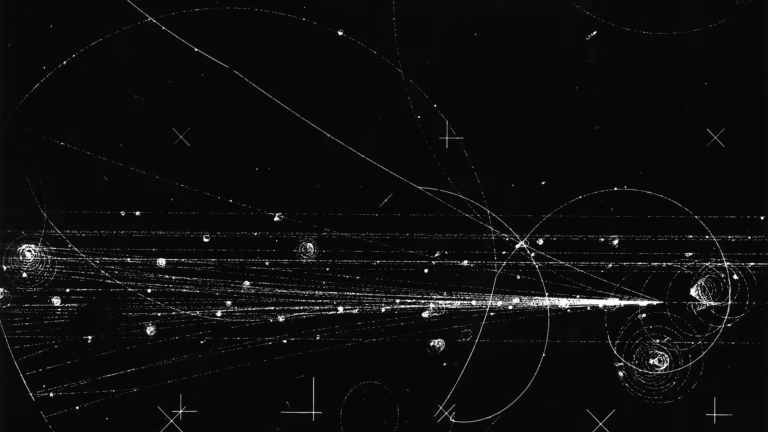Particle tracks in the 30-inch hydrogen bubble chamber at Fermilab around 1973: a 300 GeV proton collides with a proton in the liquid hydrogen and produces 26 charged particles, while low-energy electrons spiral in the magnetic field