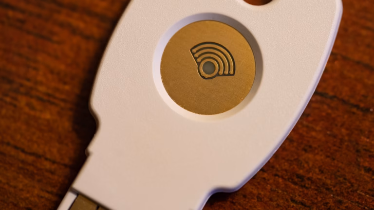 Close-up of a USB hardware security key used for two-factor authentication, resting on a wooden desk