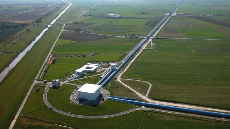 Aerial view of the Virgo gravitational-wave detector near Pisa, its central building and 3 km vacuum arms running straight across the farmland