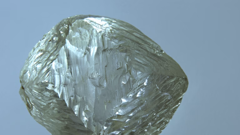 Cristallo grezzo di diamante da 0,7 carati con le facce ottaedriche striate, fotografato da vicino