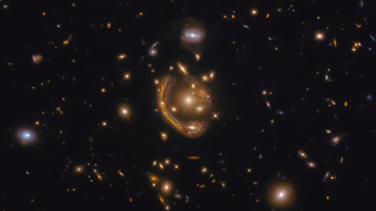 Hubble image of a distant galaxy whose light is bent into a near-complete ring around a foreground galaxy, an Einstein ring