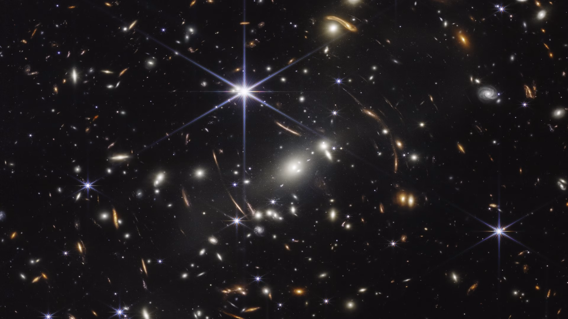 Webb's First Deep Field: thousands of distant galaxies around the galaxy cluster SMACS 0723, some stretched into arcs by gravitational lensing
