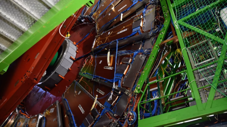 Il rivelatore CMS al CERN aperto per manutenzione: camere per muoni, cavi e strutture di supporto verdi attorno al giogo rosso del magnete